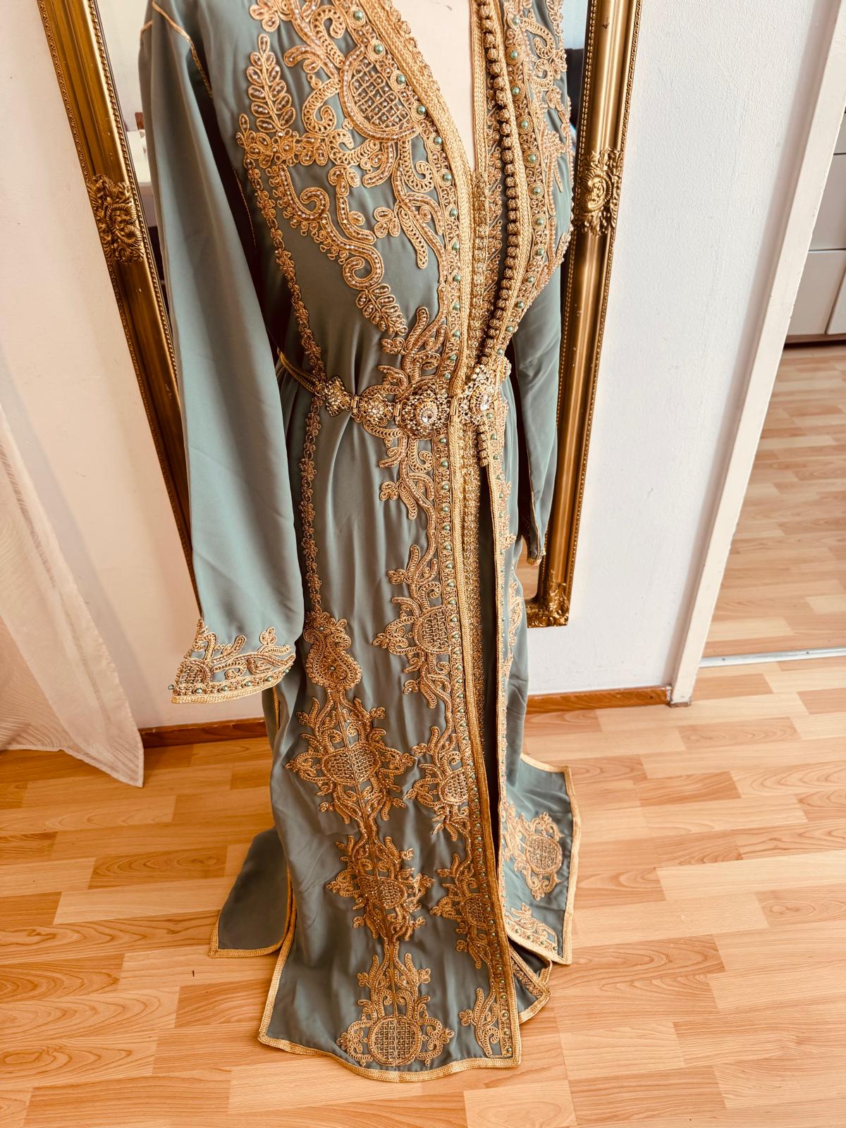 Tauche ein in orientalische Pracht mit diesem edlen marokkanischen Kaftan für Damen. In strahlendem Türkis und mit goldener Stickerei verziert, ist dieses handgefertigte Zweiteiler-Set perfekt für Ramadan, Hochzeiten, Verlobungen oder besondere Anlässe.