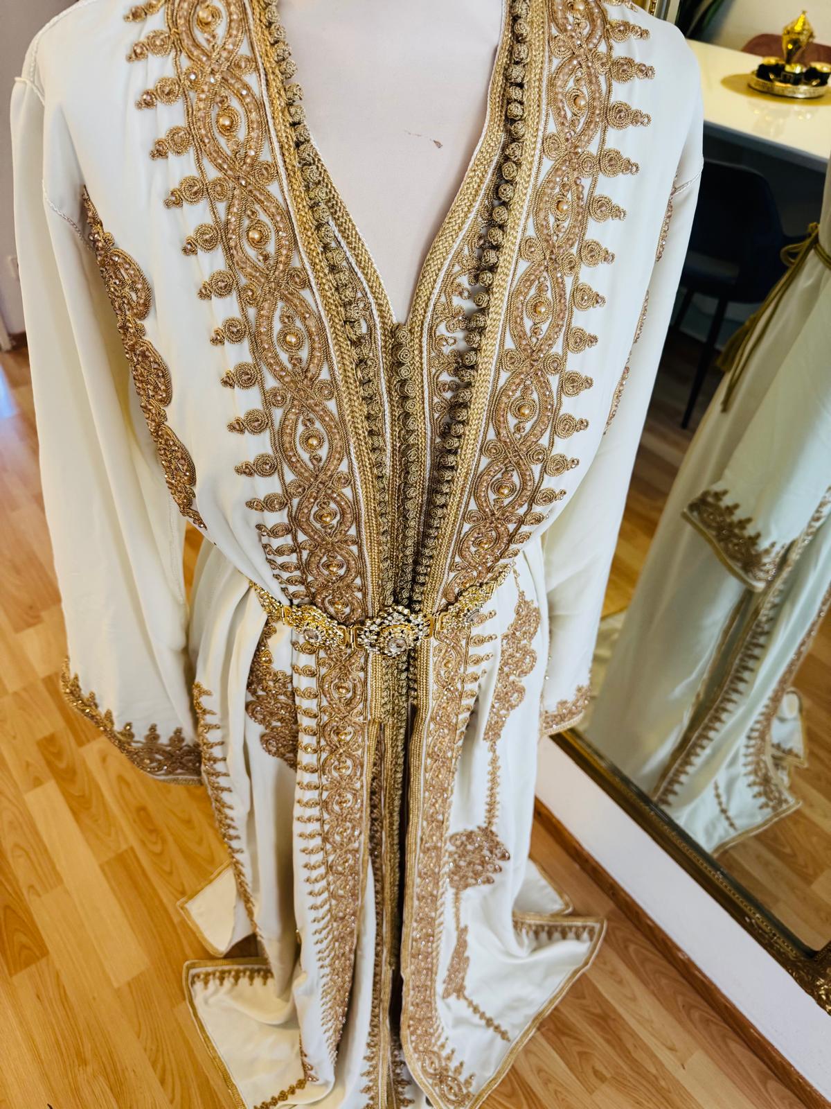 Tauche ein in orientalische Pracht mit diesem edlen marokkanischen Kaftan für Damen. In strahlendem  weiss und mit goldener Stickerei verziert, ist dieses handgefertigte Zweiteiler-Set perfekt für Ramadan, Hochzeiten, Verlobungen oder besondere Anlässe.